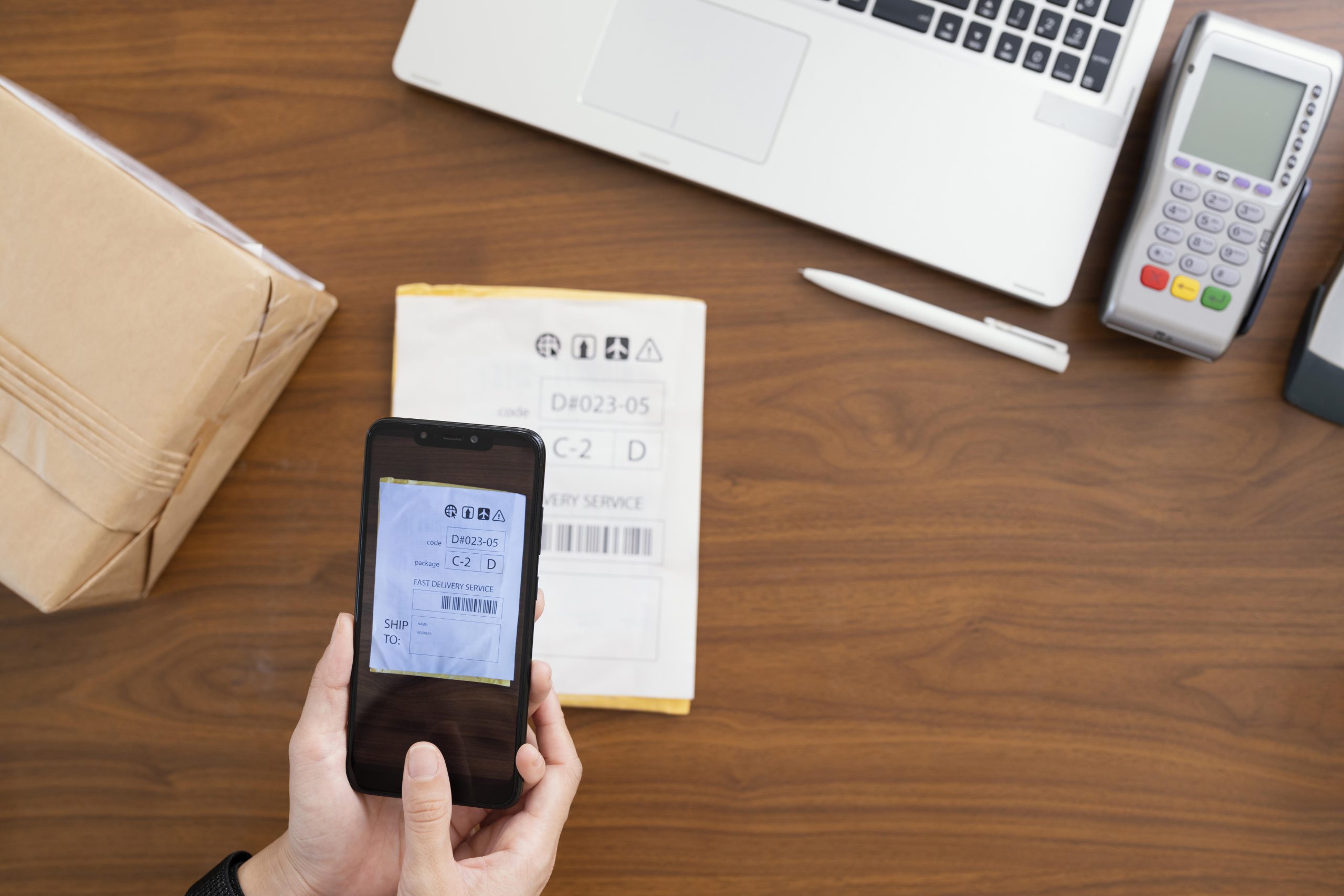 A phone is scanning a parcel information for uploading to the order tracking system